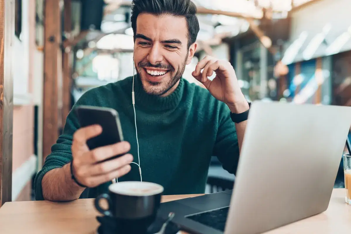 Happy man checking cell phone