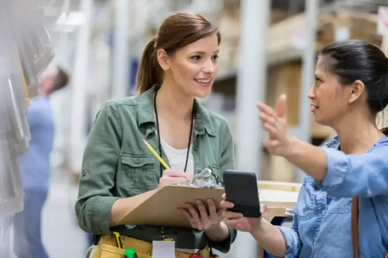 Employee assisting a customer and taking notes in a store or warehouse