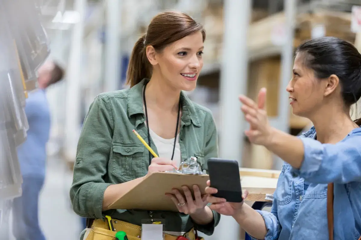 Employee assisting a customer and taking notes in a store or warehouse
